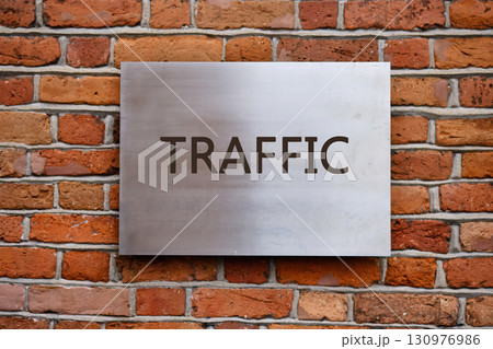 Smart city digital transformation development concept. Copy space. TRAFFIC word written on a smooth metal panel is affixed to an old brick wall Smart city digital transformation development concept. Copy space. TRAFFIC word written on a smooth metal panel is affixed to an old brick wall 130976986