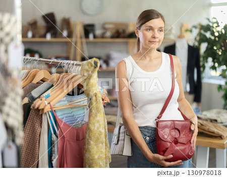 Adult women choosing handbag in store Adult women choosing handbag in store 130978018
