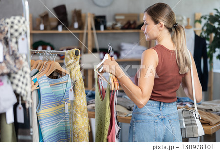 Adult woman choosing summer clothes in store 130978101
