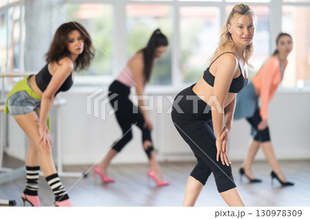Adult woman dancing high heels in group Adult woman dancing high heels in group 130978309
