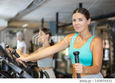 Young woman working out on elliptical machine Young woman working out on elliptical machine 130978331