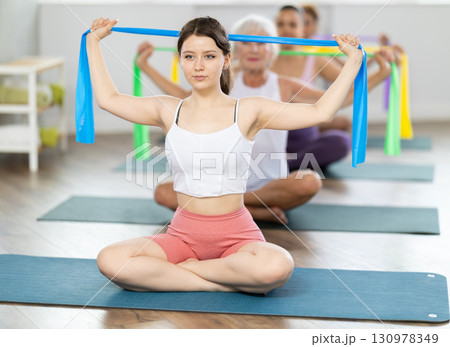 Young woman exercising with pilates band Young woman exercising with pilates band 130978349