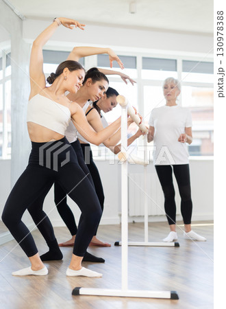 Elderly woman teacher corrects female dancers Elderly woman teacher corrects female dancers 130978388