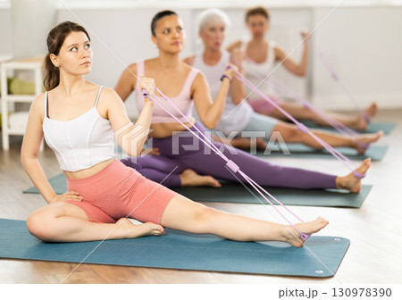Young woman exercising with pilates loop 130978390