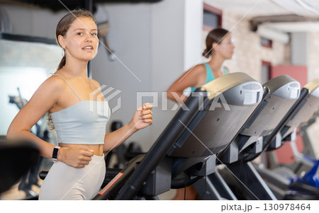 Focused motivated girl leading healthy active lifestyle doing cardio workout in gym, running on treadmill Focused motivated girl leading healthy active lifestyle doing cardio workout in gym, running on treadmill 130978464