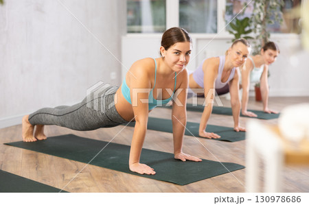 Three women doing fitness in fitness studio Three women doing fitness in fitness studio 130978686