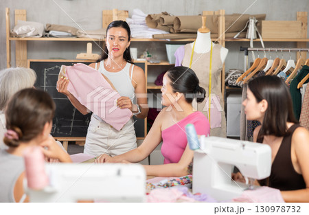 Middle-aged female teacher showing how to make dress detail 130978732