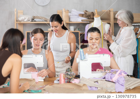 Group of women sew and work with mannequin at master class Group of women sew and work with mannequin at master class 130978735