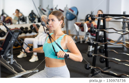 Young woman training with straps in gym 130978736