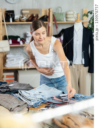 Adult woman choosing jeans in clothing store 130978757