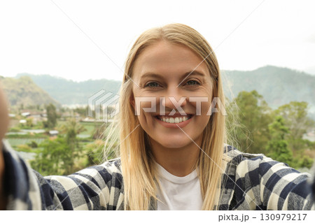 Woman cherishes a joyful moment in mountain scenery Woman cherishes a joyful moment in mountain scenery 130979217