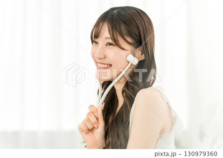 美顔ローラーを使ってマッサージするアジア人女性 130979360