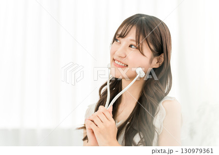 美顔ローラーを使ってマッサージするアジア人女性 130979361