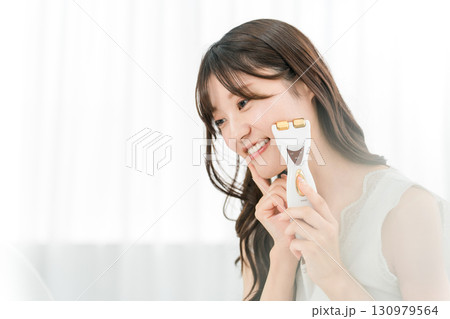 美顔器でマッサージする若いアジア人女性(スキンケア,リフトアップ) 美顔器でマッサージする若いアジア人女性(スキンケア,リフトアップ) 130979564