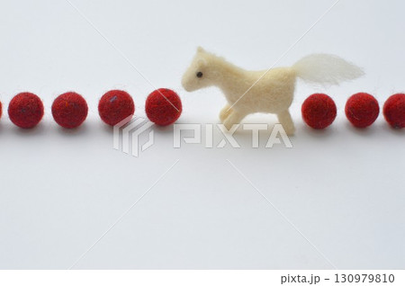 羊毛フェルトの馬と赤いフェルトボール　　 130979810