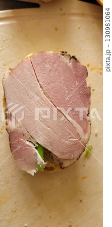 Enjoy a tasty ham slice on fresh bread with nutritious green veggies for a delightful meal Enjoy a tasty ham slice on fresh bread with nutritious green veggies for a delightful meal 130981064