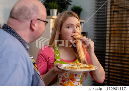 Savoring and enjoying a plate of delicious pasta in a cozy and inviting kitchen setting Savoring and enjoying a plate of delicious pasta in a cozy and inviting kitchen setting 130981117