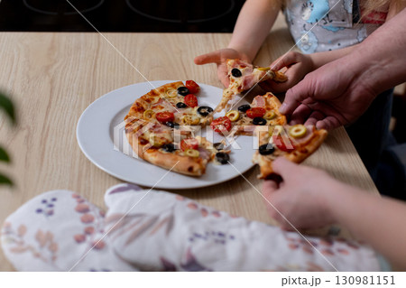 Gathering Together for Family Pizza Sharing and Enjoyment at Home During the Weekend Gathering Together for Family Pizza Sharing and Enjoyment at Home During the Weekend 130981151