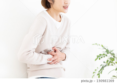 お腹の痛みに苦しむミドル女性 130981169