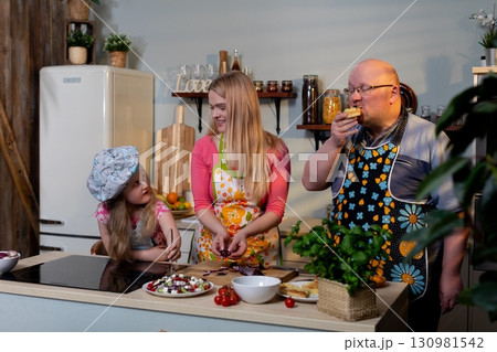 Cooking together as a family in a vibrant modern kitchen can be a joyful and fun experience Cooking together as a family in a vibrant modern kitchen can be a joyful and fun experience 130981542