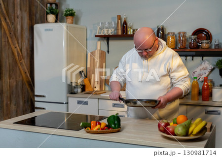 A talented chef is diligently preparing fresh and vibrant ingredients in a modern kitchen setting 130981714