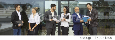 Business people meeting outdoors by office window for professional discussion 130981800