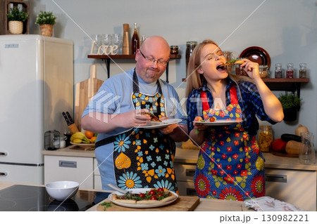 A Cheerful Cooking Duo Excitedly Preparing Delicious and Flavorful Dishes Together 130982221