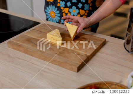 A beautiful collection of cheese slices arranged on a wooden board, perfect for gatherings A beautiful collection of cheese slices arranged on a wooden board, perfect for gatherings 130982225