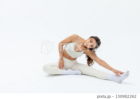 An Elegant Stretching Pose in a Minimalist Setting that embodies grace and calmness An Elegant Stretching Pose in a Minimalist Setting that embodies grace and calmness 130982262