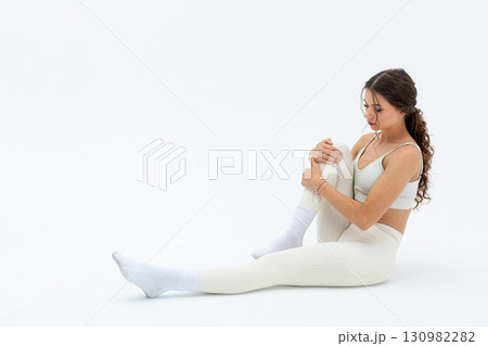 A Young Woman Engaging in Yoga Practice within a Beautifully Minimalist Space Setting A Young Woman Engaging in Yoga Practice within a Beautifully Minimalist Space Setting 130982282
