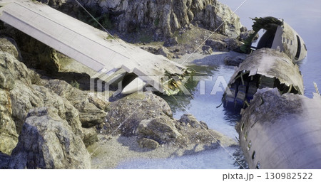 A damaged aircraft rests on a rocky shoreline, partially submerged in calm waters. Surrounding cliffs provide a rugged backdrop. The scene conveys a sense of abandonment and decay. A damaged aircraft rests on a rocky shoreline, partially submerged in calm waters. Surrounding cliffs provide a rugged backdrop. The scene conveys a sense of abandonment and decay. 130982522