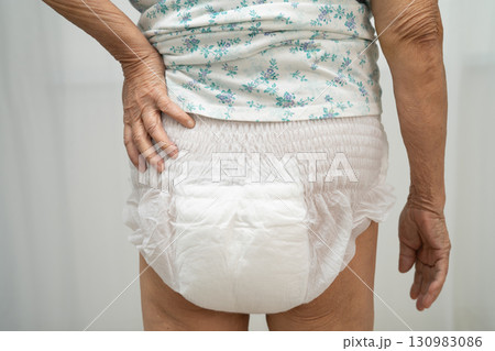 Asian senior woman patient wearing adult incontinence diaper pad in hospital. 130983086