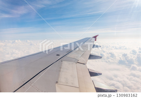 View from the airplane window at a beautiful cloudy sky and the airplane wing 130983162
