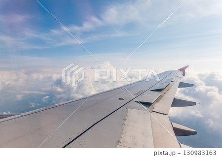 View from the airplane window at a beautiful cloudy sky and the airplane wing 130983163