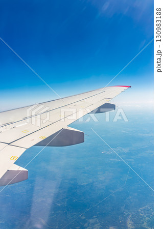 View from the airplane window at a beautiful blue clear sky and the airplane wing 130983188