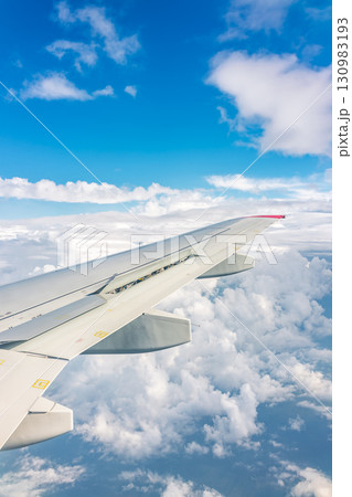 View from the airplane window at a beautiful cloudy sky and the airplane wing 130983193