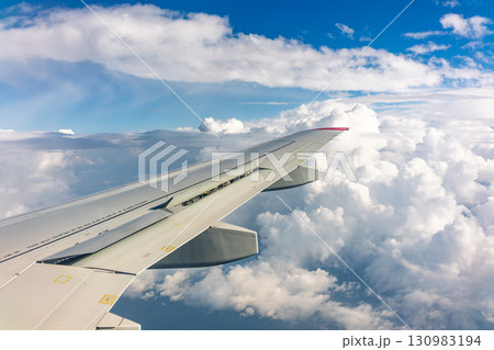 View from the airplane window at a beautiful cloudy sky and the airplane wing 130983194
