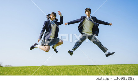 青空の下でジャンプする男女の高校生 青空の下でジャンプする男女の高校生 130983888