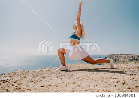 Woman Practicing Yoga on a Cliff with Ocean View 130984601