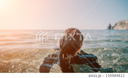 Woman Sea Sunset Water; A woman wading in the sea at sunset. Woman Sea Sunset Water; A woman wading in the sea at sunset. 130984612