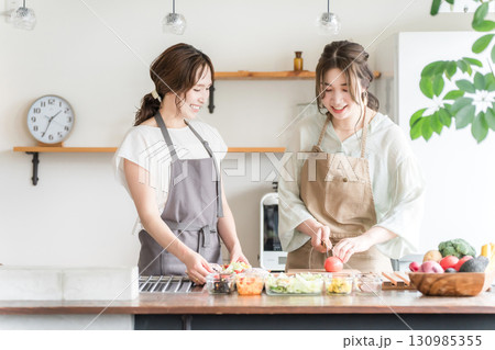 料理教室・クッキングスクールで料理を教える講師の女性と生徒の女性 130985355