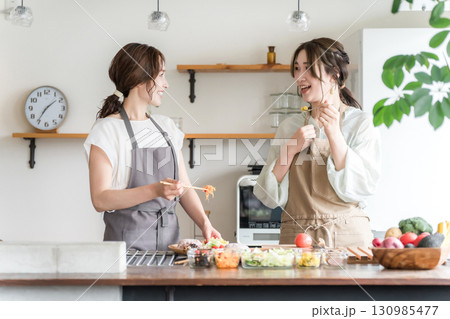 料理教室・クッキングスクールで料理を教える講師の女性と生徒の女性（味見,テイスティング） 130985477