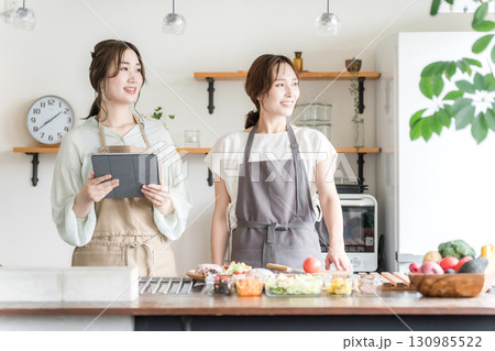 料理教室・クッキングスクールで料理を教える講師の女性と生徒の女性 料理教室・クッキングスクールで料理を教える講師の女性と生徒の女性 130985522