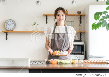 キッチンでワンプレートランチを盛り付ける主婦 130985773