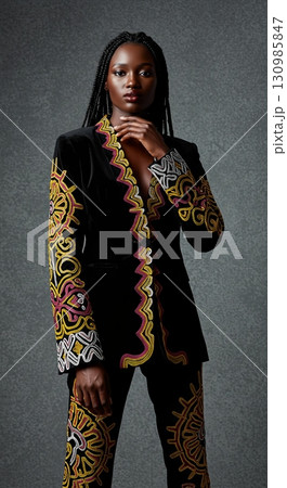 Stunning african model in a black velvet suit with vibrant traditional ethnic embroidery 130985847