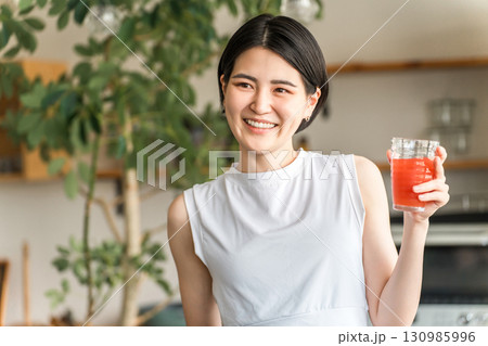 野菜ジュースを飲むスポーツウェア姿の若アジア人女性(便秘改善・むくみ予防・腸内環境) 野菜ジュースを飲むスポーツウェア姿の若アジア人女性(便秘改善・むくみ予防・腸内環境) 130985996