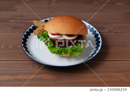お皿にのせたテリヤキバーガー 木のテーブル 130986259