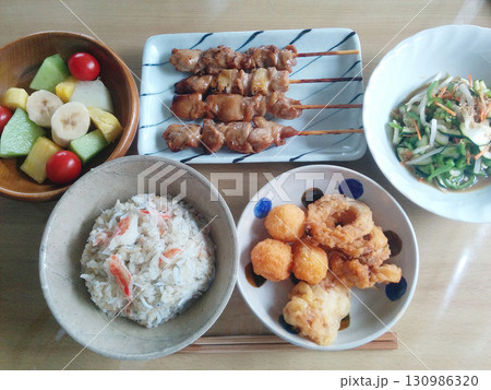日本酒の晩酌のための夕食の一例～焼き鳥(たれ)，揚げ物とカニ飯の組み合わせ，小鉢・デザート付き 130986320