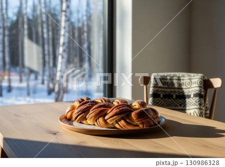 Estonian kringel a sweet braided cinnamon bread on a table with a winter forest view 130986328