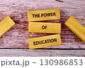 Concept words THE POWER OF EDUCATION is assembled from blocks on wooden boards, top view 130986853
